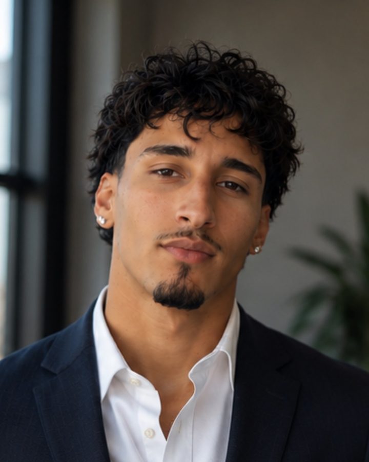 Skyler Reyes, founder of Kreated, in a navy blazer and white shirt beside a window.